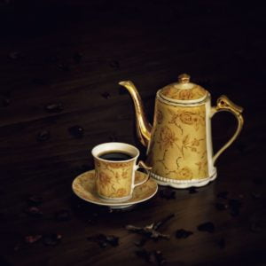 white and brown ceramic teapot beside white ceramic mug on brown wooden table